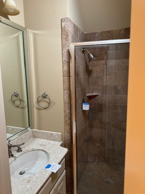 bathroom featuring vanity and a shower with door