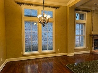 unfurnished dining area with crown molding, wood-type flooring, and a notable chandelier