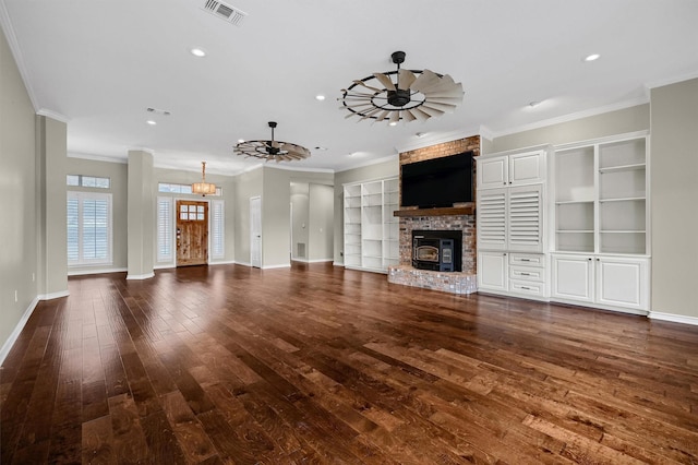 unfurnished living room featuring dark wood-type flooring, ceiling fan, crown molding, and a brick fireplace