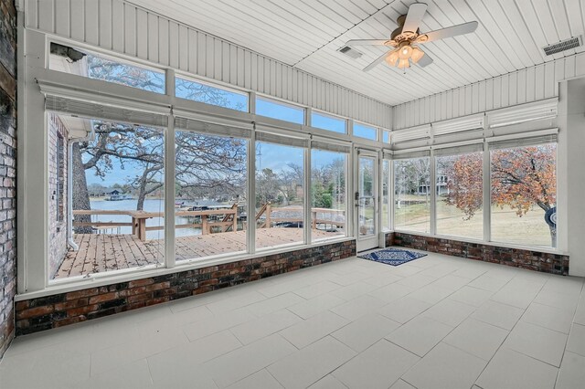 unfurnished sunroom with ceiling fan and a water view