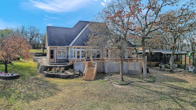 back of property featuring a deck and a lawn