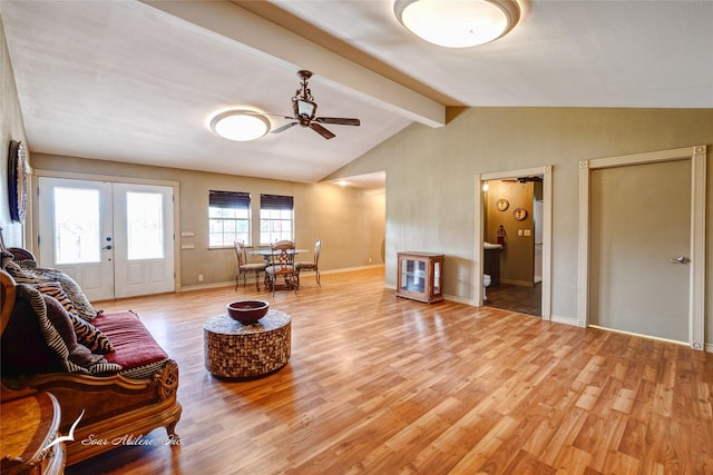 living room with ceiling fan, vaulted ceiling with beams, light wood-type flooring, and french doors