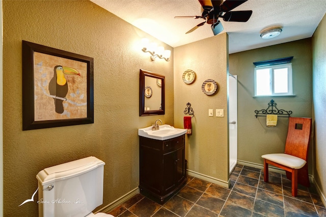 bathroom featuring vanity, a textured ceiling, ceiling fan, and toilet