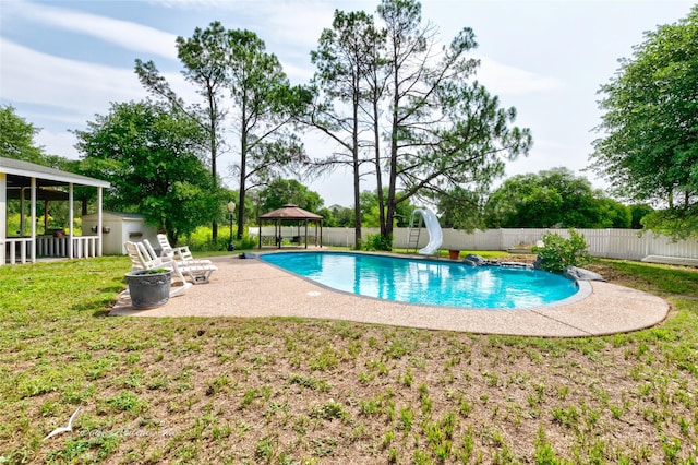 view of pool with a gazebo, a water slide, a lawn, a storage unit, and a patio