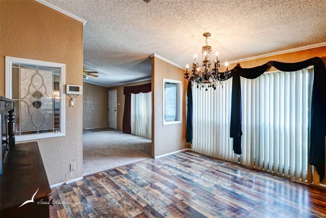 unfurnished dining area with lofted ceiling, ceiling fan with notable chandelier, ornamental molding, and hardwood / wood-style flooring