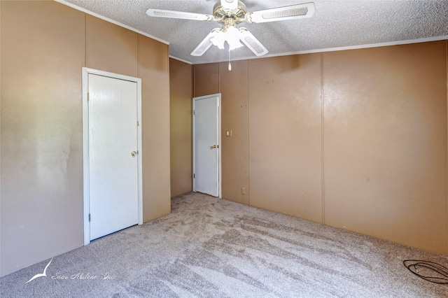 carpeted empty room with ceiling fan and a textured ceiling