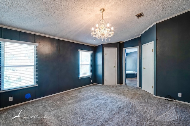 unfurnished bedroom featuring lofted ceiling, a textured ceiling, ornamental molding, carpet floors, and a notable chandelier