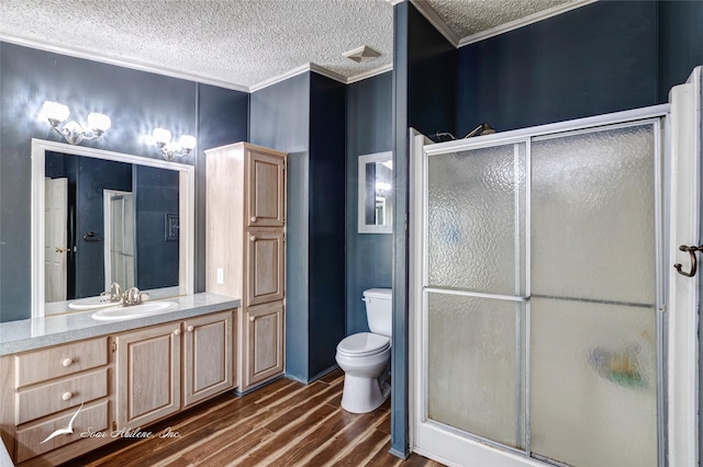 bathroom with hardwood / wood-style flooring, ornamental molding, vanity, an enclosed shower, and toilet