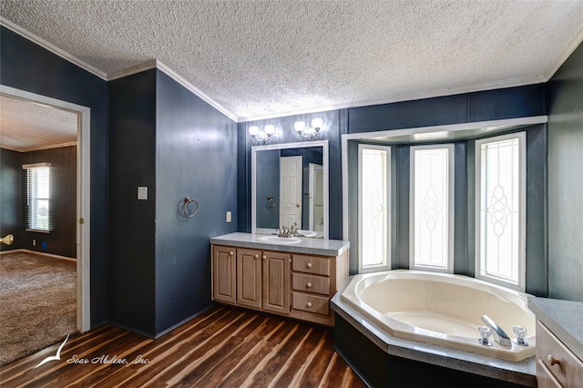 bathroom with crown molding, a textured ceiling, vanity, a tub, and hardwood / wood-style floors