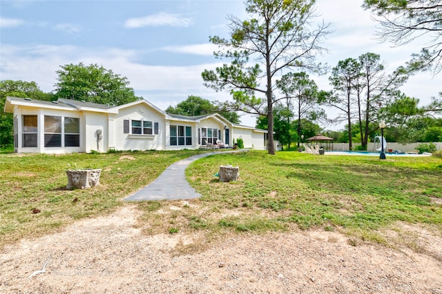 ranch-style house with a garage, a front yard, and a sunroom