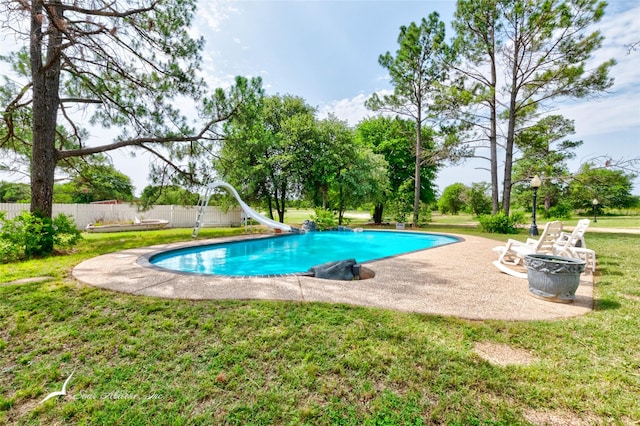 view of pool featuring a patio, a water slide, and a yard