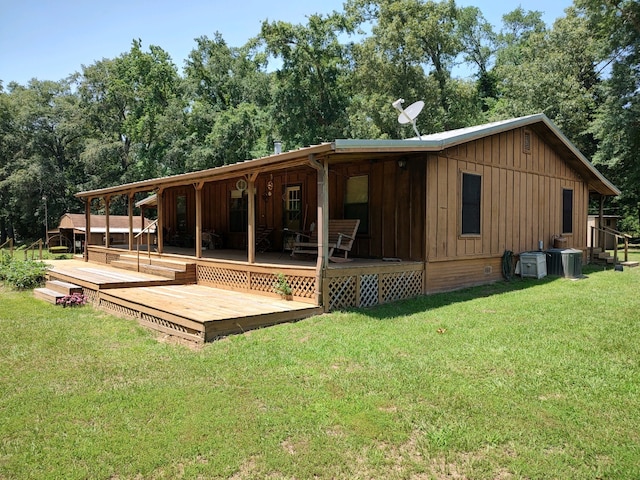 rear view of property featuring a deck and a lawn