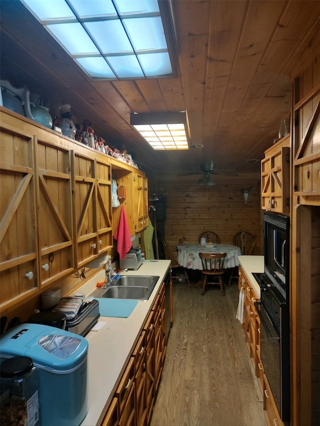 misc room featuring ceiling fan, wood ceiling, wooden walls, sink, and hardwood / wood-style flooring