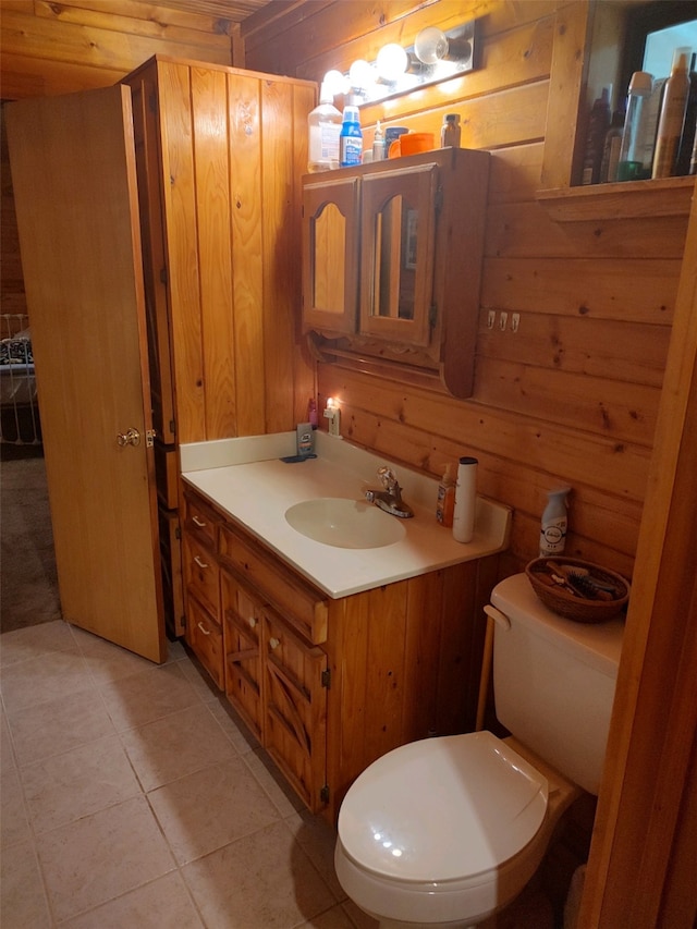 bathroom featuring tile floors, toilet, vanity, and wood walls