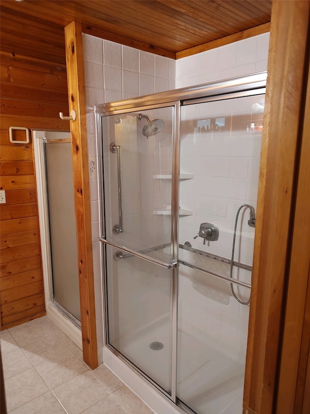 bathroom with tile floors, a shower with door, wood walls, and wood ceiling