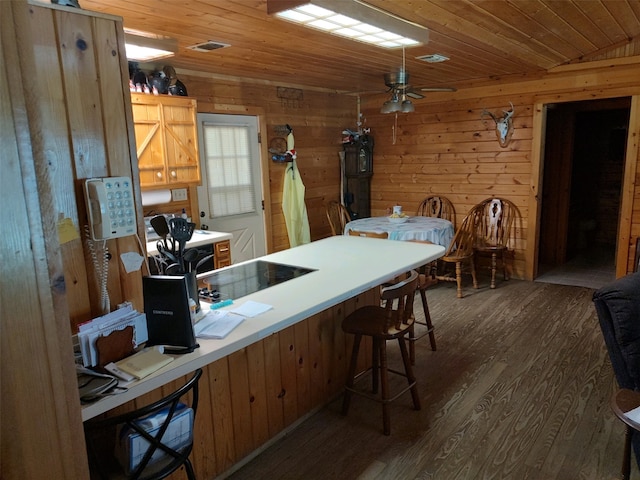 kitchen with kitchen peninsula, ceiling fan, hardwood / wood-style flooring, wooden ceiling, and wooden walls