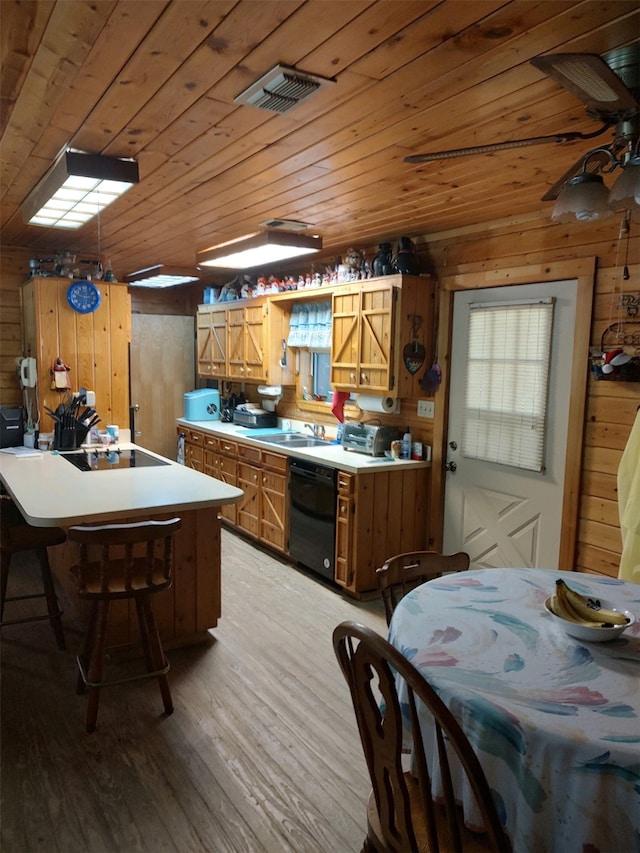 kitchen with black appliances, wooden walls, light wood-type flooring, and ceiling fan