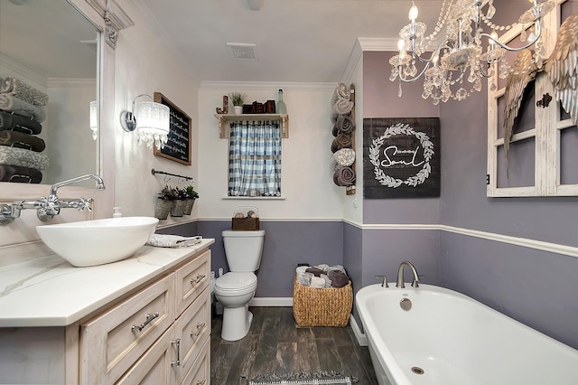 bathroom featuring hardwood / wood-style floors, an inviting chandelier, crown molding, toilet, and a tub to relax in