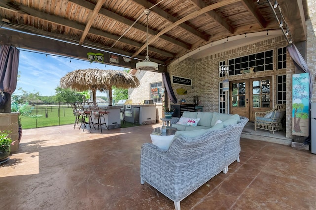 view of patio / terrace with an outdoor kitchen, an outdoor hangout area, and exterior bar