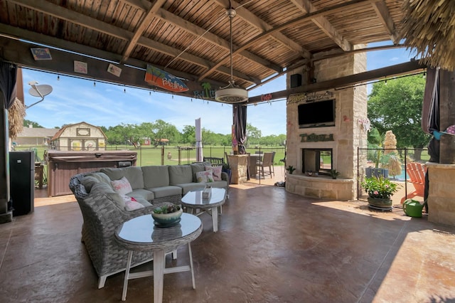 view of patio / terrace featuring an outdoor living space with a fireplace, a gazebo, and a hot tub