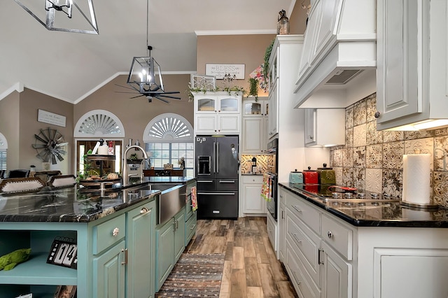 kitchen with white cabinetry, green cabinetry, a kitchen island with sink, and high end black refrigerator