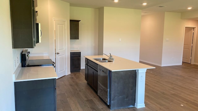 kitchen with dark hardwood / wood-style flooring, stainless steel appliances, an island with sink, and sink