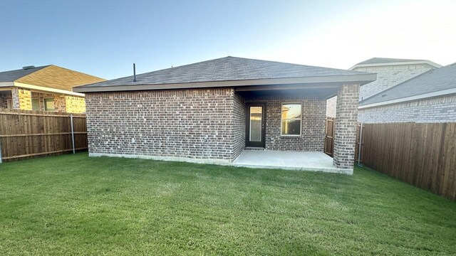 rear view of house with a patio area and a yard