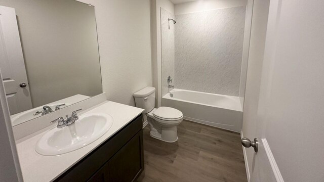 full bathroom featuring washtub / shower combination, vanity, hardwood / wood-style flooring, and toilet