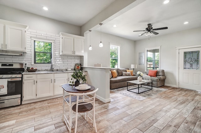 kitchen featuring white cabinetry, a wealth of natural light, and stainless steel range oven