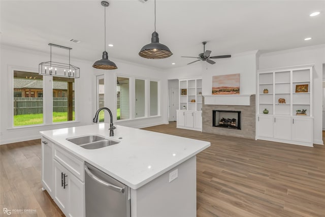 kitchen with sink, stainless steel dishwasher, an island with sink, decorative light fixtures, and white cabinetry