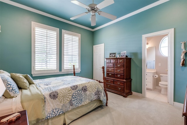 bedroom featuring ceiling fan, ornamental molding, ensuite bathroom, and light carpet