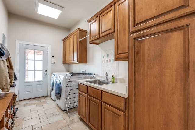 clothes washing area featuring sink, cabinets, and independent washer and dryer