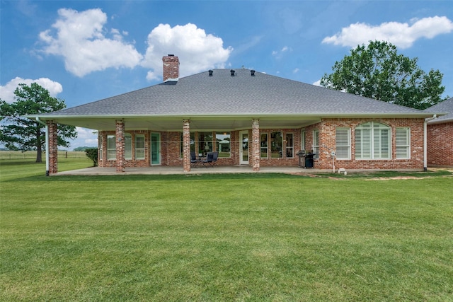 back of house featuring a lawn and a patio area