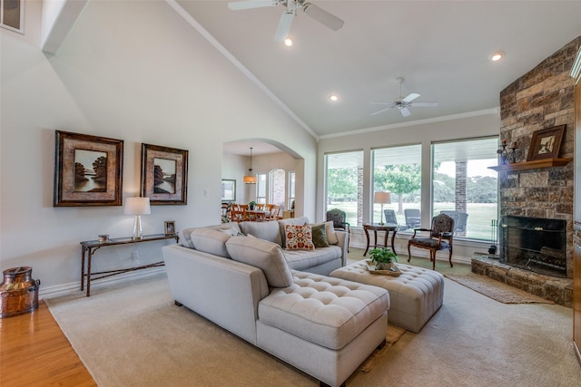 living room featuring ceiling fan, a fireplace, high vaulted ceiling, and light hardwood / wood-style floors