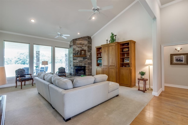 living room with a fireplace, ceiling fan, light hardwood / wood-style flooring, and crown molding