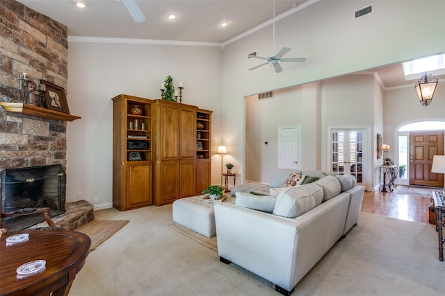 living room with ceiling fan, ornamental molding, a fireplace, and high vaulted ceiling