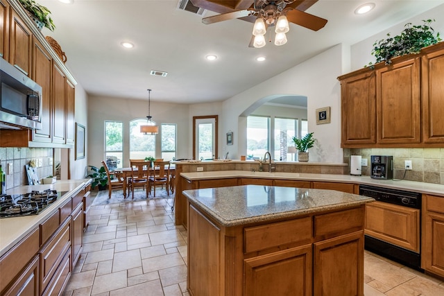 12198 Bell Rd, Pilot Point, TX 76258 - kitchen featuring paneled dishwasher, stainless steel microwave, recessed lighting, backsplash, and brown cabinetry