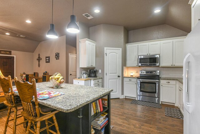 kitchen featuring stainless steel appliances, lofted ceiling, white cabinets, dark hardwood / wood-style floors, and pendant lighting