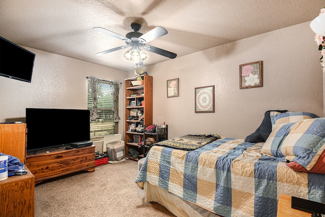 carpeted bedroom featuring a textured ceiling and ceiling fan