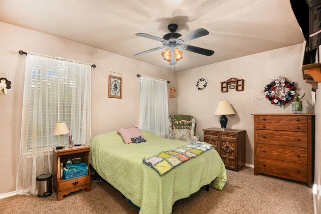 bedroom with a textured ceiling, light carpet, and ceiling fan