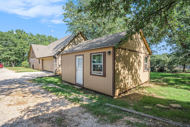 view of outdoor structure with a lawn and a garage