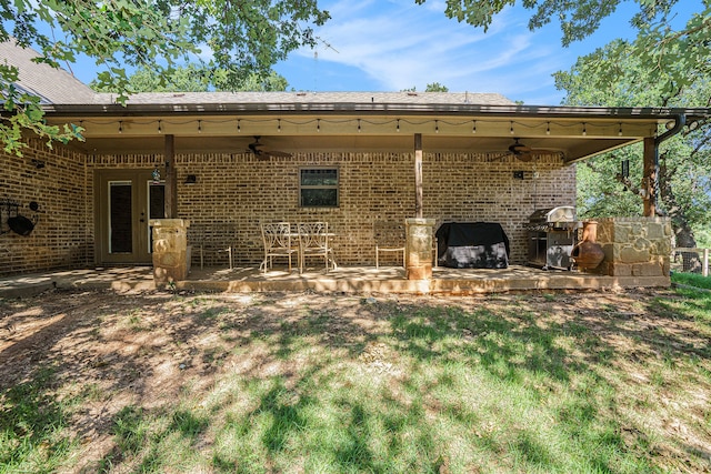 back of property featuring ceiling fan, a lawn, and a patio area