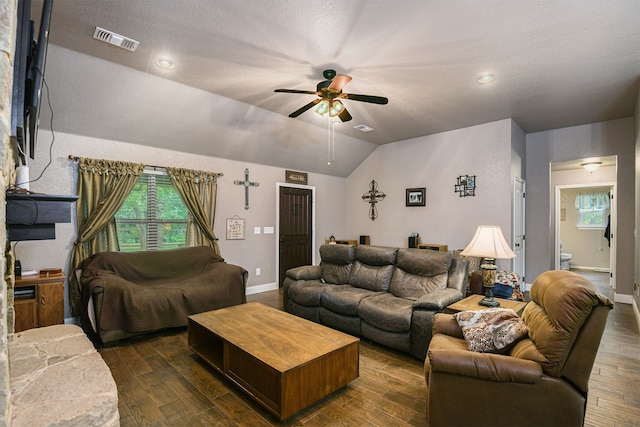 living room with ceiling fan, lofted ceiling, a textured ceiling, and dark hardwood / wood-style floors