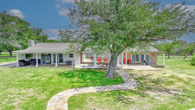 rear view of house featuring a lawn, a patio area, and an outdoor living space