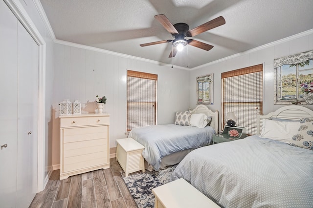 bedroom featuring a closet, ceiling fan, crown molding, and hardwood / wood-style flooring