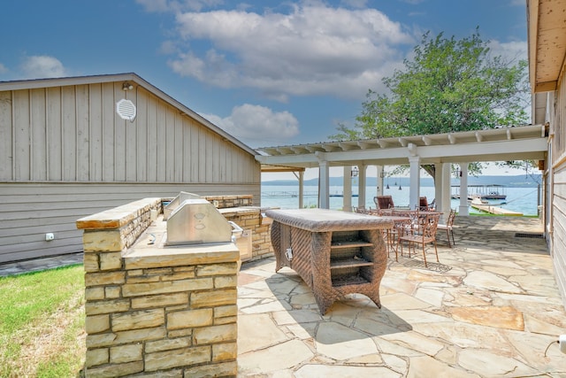 view of patio / terrace featuring a water view and exterior kitchen