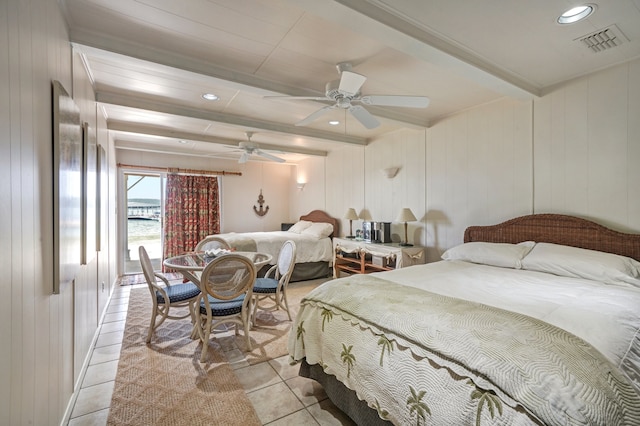 tiled bedroom featuring beam ceiling, ceiling fan, and wood walls