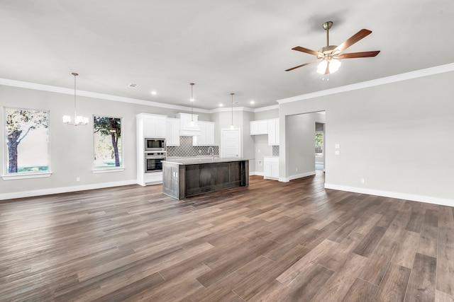 kitchen featuring white cabinets, an island with sink, dark hardwood / wood-style floors, and decorative light fixtures