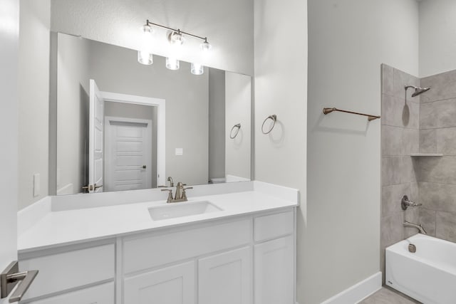 bathroom featuring vanity and tiled shower / bath