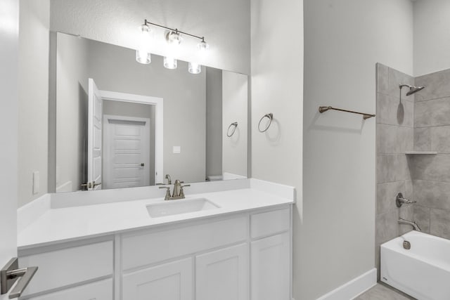 bathroom featuring tiled shower / bath and vanity